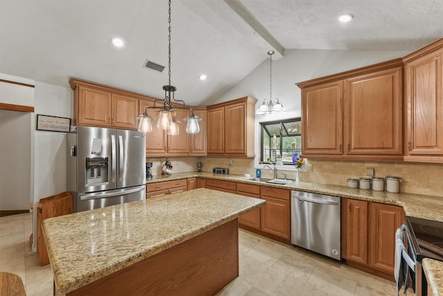 103 Whippoorwill Dr, Livingston, TX 77351 - kitchen with stainless steel appliances, a sink, light stone countertops, backsplash, and brown cabinetry