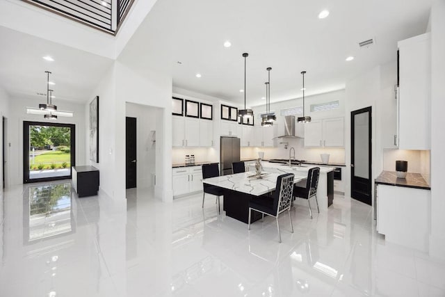 3379 Tampa St, Houston, TX 77021 - kitchen featuring wall chimney range hood, freestanding refrigerator, a large island, recessed lighting, and white cabinetry
