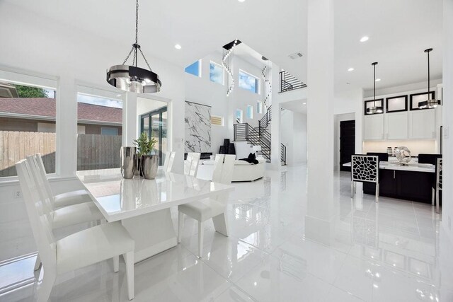 3379 Tampa St, Houston, TX 77021 - dining room featuring light tile patterned flooring, a chandelier, a high ceiling, recessed lighting, and stairs