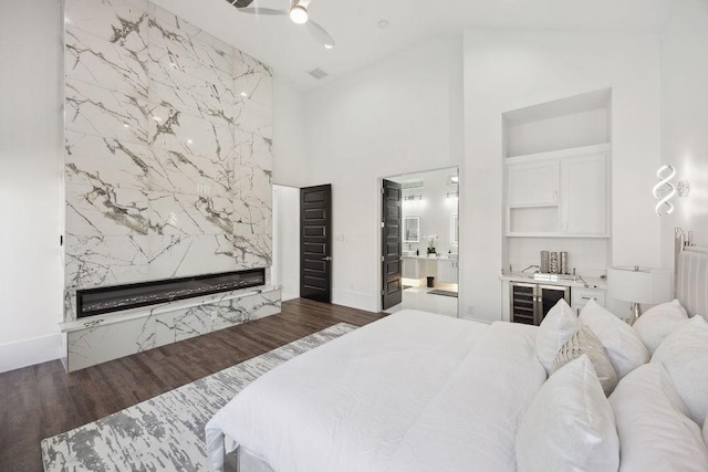 3379 Tampa St, Houston, TX 77021 - bedroom featuring beverage cooler, a high end fireplace, high vaulted ceiling, dark wood-type flooring, and connected bathroom