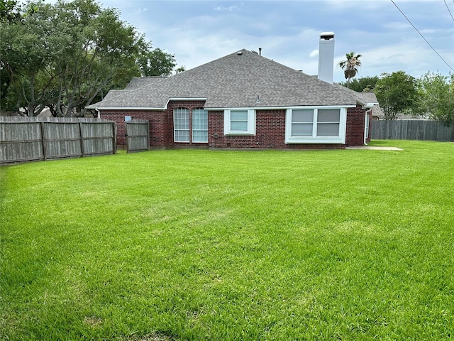 5035 Chappel Hill Dr, Missouri City, TX 77459 - back of property featuring a shingled roof, a chimney, and brick siding