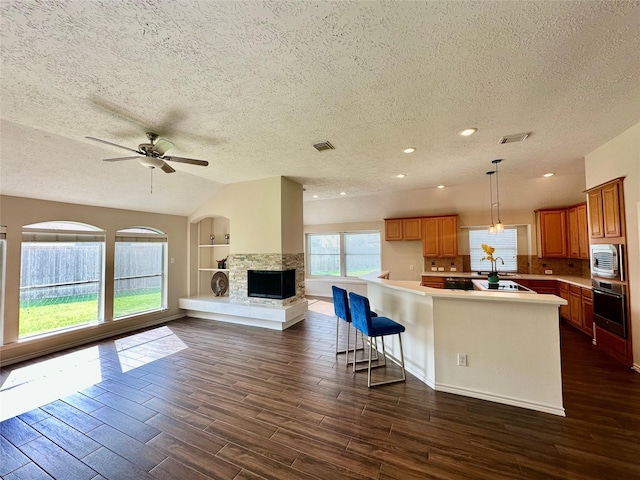 5035 Chappel Hill Dr, Missouri City, TX 77459 - kitchen featuring stainless steel appliances, a textured ceiling, open floor plan, brown cabinets, and ceiling fan