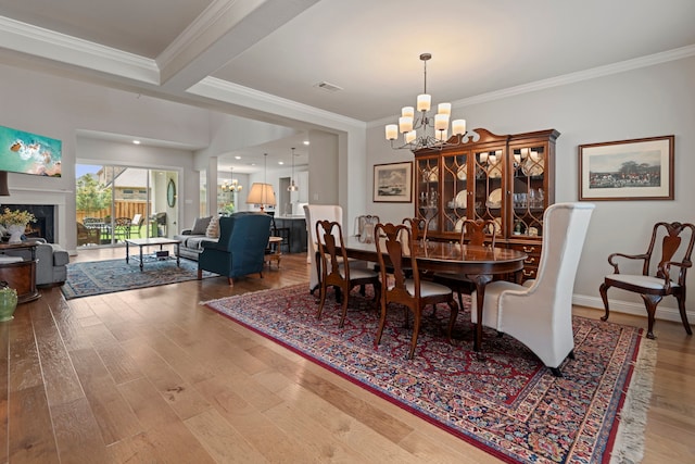 28228 Cedar Peak Dr, Spring, TX 77386 - dining room featuring a chandelier, crown molding, wood finished floors, and a lit fireplace
