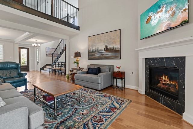 28228 Cedar Peak Dr, Spring, TX 77386 - living area featuring stairs, wood finished floors, a chandelier, baseboards, and a fireplace