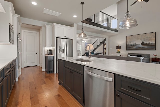 28228 Cedar Peak Dr, Spring, TX 77386 - kitchen featuring appliances with stainless steel finishes, a sink, a ceiling fan, light wood-style floors, and white cabinets