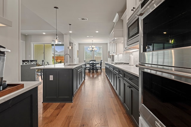 28228 Cedar Peak Dr, Spring, TX 77386 - kitchen featuring stainless steel appliances, light countertops, light wood finished floors, a sink, and a chandelier