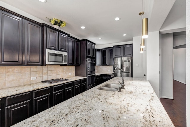 8106 Yarrow Dr, Cypress, TX 77433 - kitchen featuring appliances with stainless steel finishes, a sink, wood finished floors, light stone counters, and recessed lighting