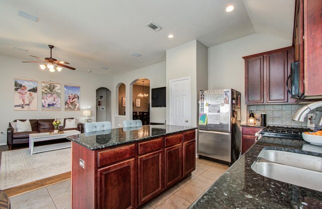 1918 Hollow Mist Ln, Pearland, TX 77581 - kitchen featuring freestanding refrigerator, light tile patterned flooring, arched walkways, black microwave, and recessed lighting