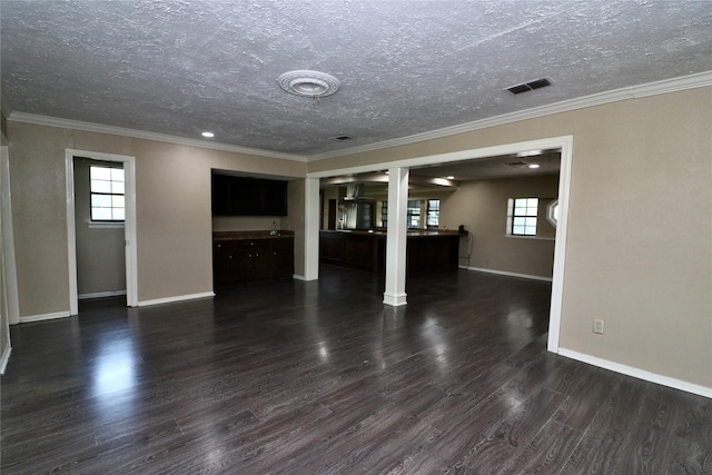 19207 Fm 2100th Rd, Crosby, TX 77532 - unfurnished living room featuring a textured ceiling, healthy amount of natural light, dark wood-style floors, baseboards, and ornamental molding