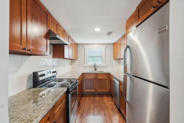 2604 Cochran St, Houston, TX 77009 - kitchen with stainless steel appliances, under cabinet range hood, a sink, dark wood-style flooring, and light stone countertops