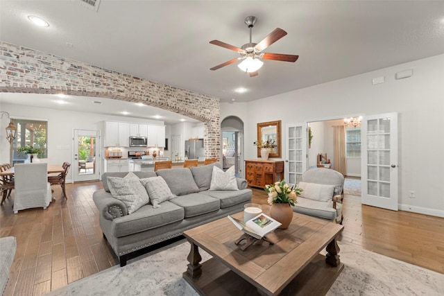 18731 Pilot Knolls Dr, Cypress, TX 77433 - living room featuring light wood finished floors, arched walkways, ceiling fan, french doors, and recessed lighting