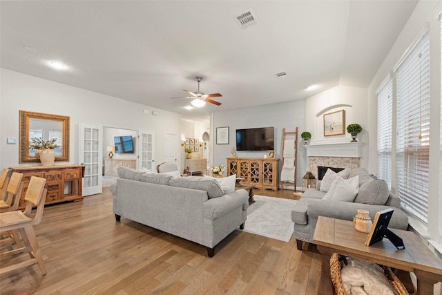 18731 Pilot Knolls Dr, Cypress, TX 77433 - living room with light wood-style flooring, a ceiling fan, and a stone fireplace