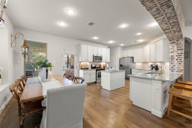 18731 Pilot Knolls Dr, Cypress, TX 77433 - kitchen with stainless steel appliances, light wood finished floors, white cabinets, a sink, and recessed lighting