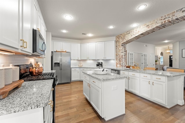 18731 Pilot Knolls Dr, Cypress, TX 77433 - kitchen with appliances with stainless steel finishes, a peninsula, light wood finished floors, white cabinetry, and recessed lighting