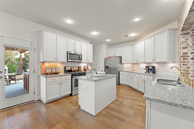 18731 Pilot Knolls Dr, Cypress, TX 77433 - kitchen with stainless steel appliances, a sink, white cabinetry, tasteful backsplash, and light wood-style floors
