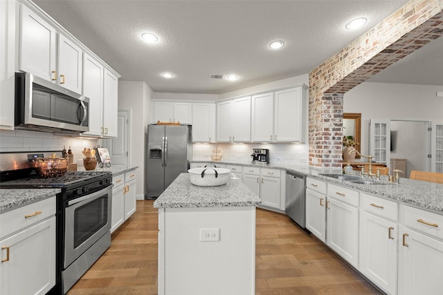 18731 Pilot Knolls Dr, Cypress, TX 77433 - kitchen with appliances with stainless steel finishes, white cabinets, backsplash, a kitchen island, and recessed lighting