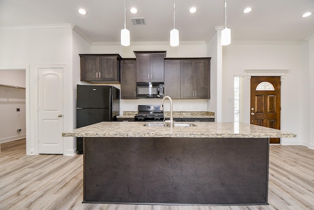 6718 Utah St, Houston, TX 77091 - kitchen with black appliances, a sink, light wood finished floors, dark brown cabinetry, and an island with sink