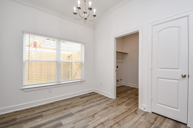 6718 Utah St, Houston, TX 77091 - unfurnished dining area with ornamental molding, a chandelier, light wood-style floors, vaulted ceiling, and baseboards