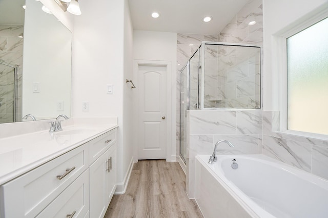 6727 Utah St, Houston, TX 77091 - full bathroom featuring vanity, a garden tub, a marble finish shower, wood finished floors, and recessed lighting