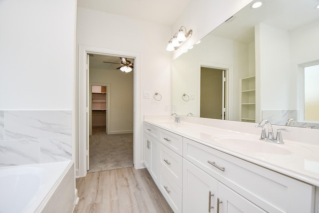 6727 Utah St, Houston, TX 77091 - full bathroom with double vanity, a bath, wood finished floors, and a walk in closet