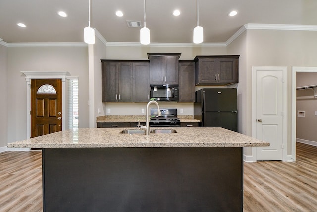 6519 Utah St, Houston, TX 77091 - kitchen featuring black appliances, crown molding, dark brown cabinetry, a center island with sink, and light wood-type flooring