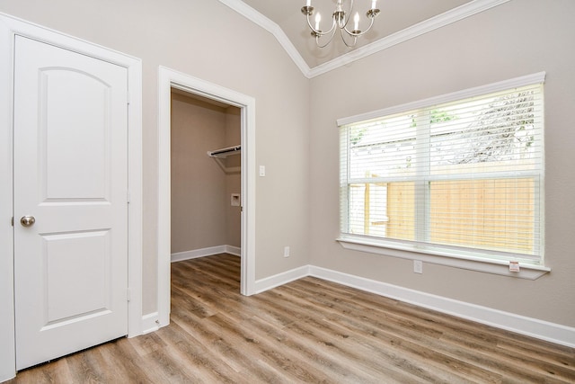 6519 Utah St, Houston, TX 77091 - unfurnished bedroom with crown molding, a chandelier, light wood-style flooring, a walk in closet, and a closet