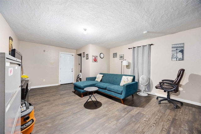 1206 Dewalt St, Houston, TX 77088 - living area with dark wood-style flooring, a textured ceiling, and baseboards