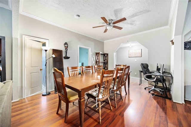 1206 Dewalt St, Houston, TX 77088 - dining space featuring wood finished floors, a ceiling fan, ornamental molding, arched walkways, and a textured ceiling