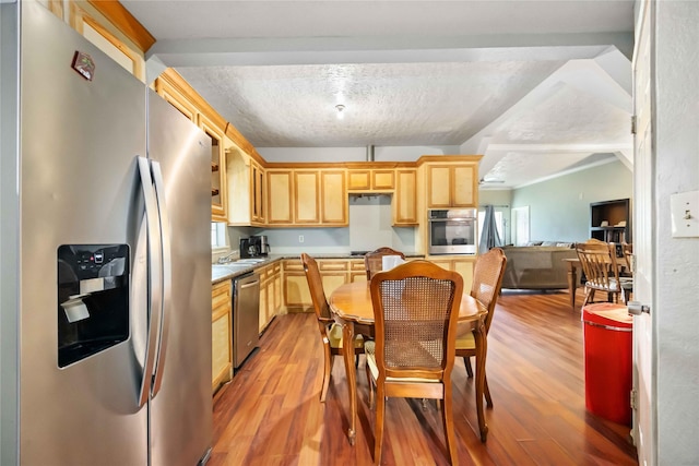 1206 Dewalt St, Houston, TX 77088 - kitchen featuring appliances with stainless steel finishes, light brown cabinets, light wood finished floors, a textured ceiling, and light countertops