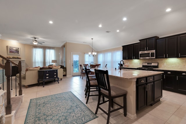 17915 Tall Chestnut St, Cypress, TX 77429 - kitchen featuring stainless steel microwave, range with gas cooktop, ornamental molding, dark cabinets, and plenty of natural light