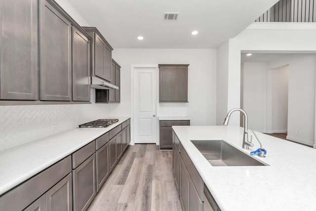 21118 Chelton Beach Dr, Cypress, TX 77433 - kitchen with a sink, light wood finished floors, backsplash, under cabinet range hood, and recessed lighting