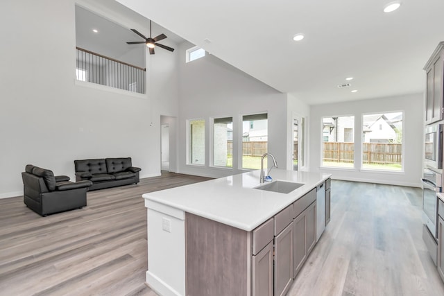 21118 Chelton Beach Dr, Cypress, TX 77433 - kitchen with a sink, open floor plan, light wood-style floors, an island with sink, and ceiling fan