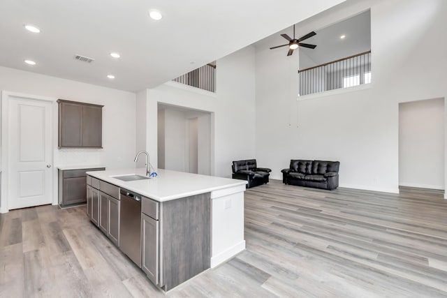 21118 Chelton Beach Dr, Cypress, TX 77433 - kitchen with a sink, dishwasher, open floor plan, a high ceiling, and light wood-style flooring