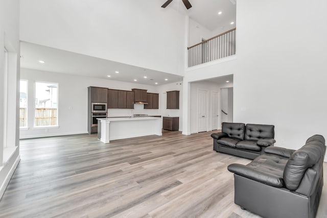 21118 Chelton Beach Dr, Cypress, TX 77433 - living room with ceiling fan, light wood-style flooring, recessed lighting, a high ceiling, and baseboards