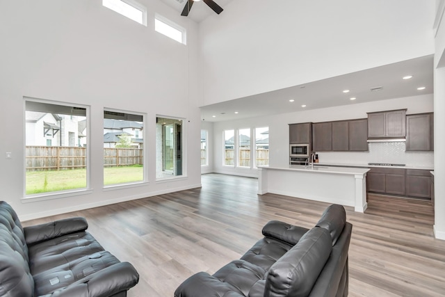 21118 Chelton Beach Dr, Cypress, TX 77433 - living room featuring ceiling fan, plenty of natural light, a towering ceiling, light wood-style floors, and recessed lighting