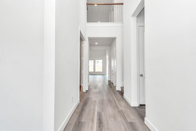 21118 Chelton Beach Dr, Cypress, TX 77433 - hall featuring baseboards, wood finished floors, and a towering ceiling