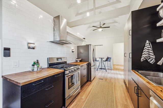 542 Arlington St, Houston, TX 77007 - kitchen with butcher block countertops, appliances with stainless steel finishes, wall chimney exhaust hood, and light wood-style floors