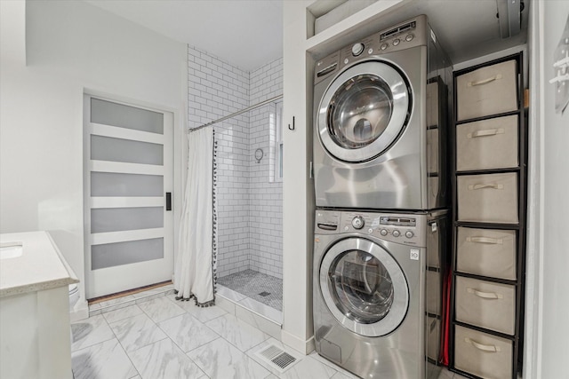 542 Arlington St, Houston, TX 77007 - laundry room featuring stacked washer / dryer and light marble finish flooring