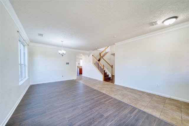 6610 Autumn Sunset Ln, Spring, TX 77379 - unfurnished living room with a chandelier, stairs, wood finished floors, a textured ceiling, and ornamental molding