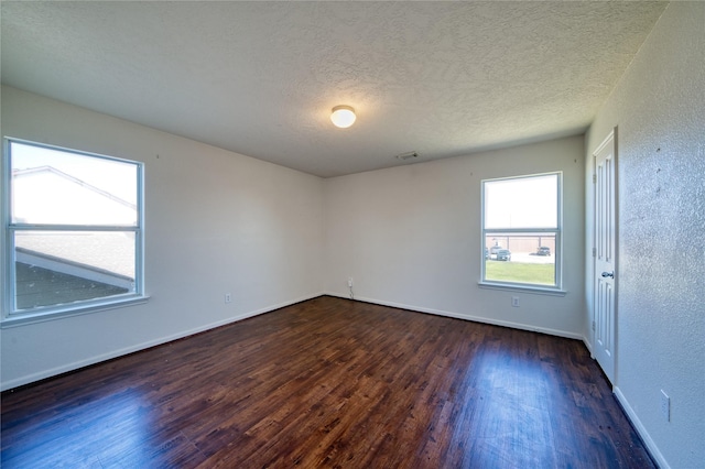 6610 Autumn Sunset Ln, Spring, TX 77379 - empty room featuring dark wood-type flooring, a textured ceiling, baseboards, and a textured wall