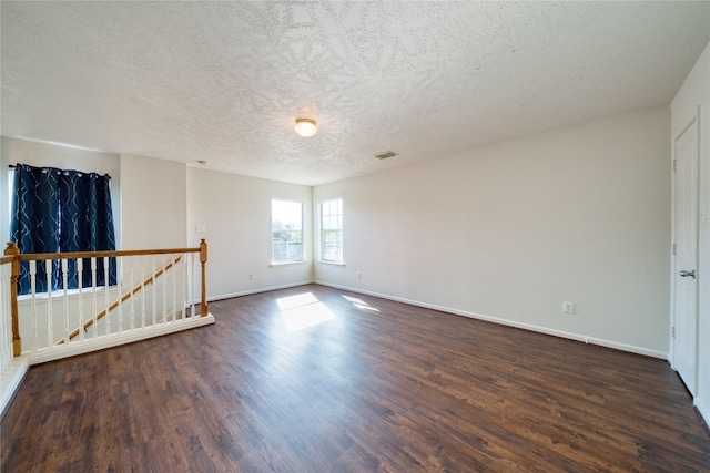 6610 Autumn Sunset Ln, Spring, TX 77379 - spare room with dark wood-type flooring, a textured ceiling, and baseboards