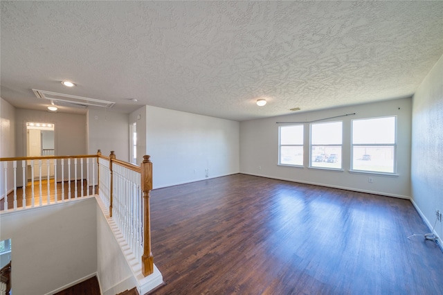 6610 Autumn Sunset Ln, Spring, TX 77379 - spare room with attic access, a textured ceiling, wood finished floors, and baseboards