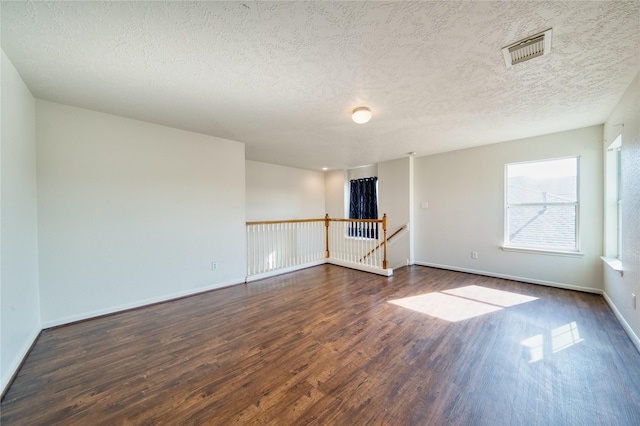6610 Autumn Sunset Ln, Spring, TX 77379 - empty room featuring dark wood-style flooring, a textured ceiling, and baseboards