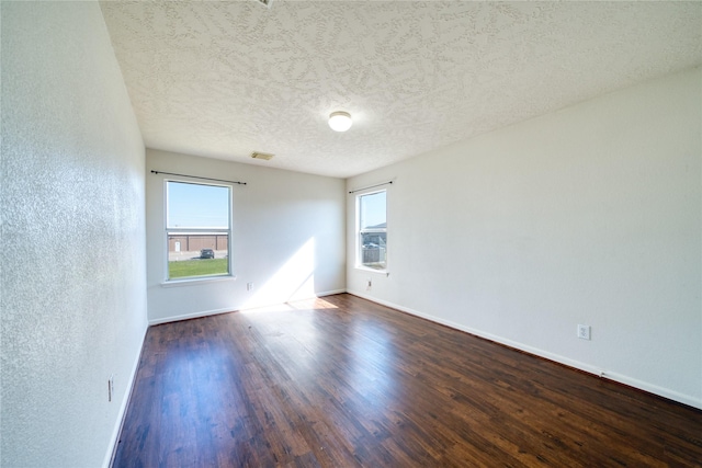 6610 Autumn Sunset Ln, Spring, TX 77379 - empty room featuring dark wood-type flooring, a textured ceiling, baseboards, and a textured wall