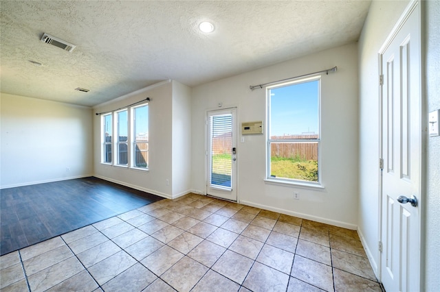 6610 Autumn Sunset Ln, Spring, TX 77379 - spare room featuring plenty of natural light, a textured ceiling, tile patterned floors, and baseboards