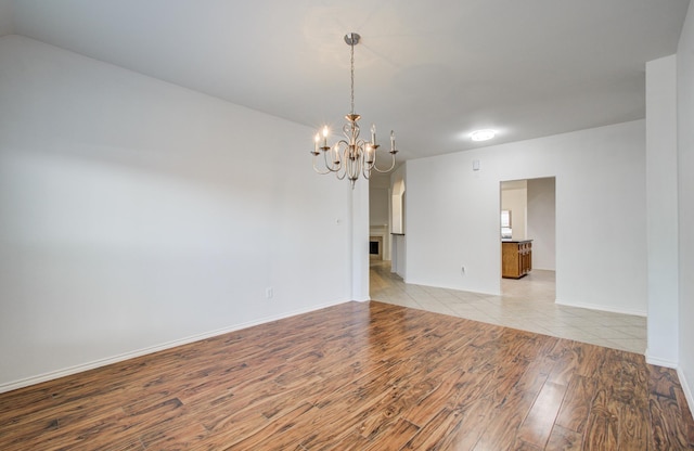 12223 Ayrshire Pl, Houston, TX 77089 - empty room with a chandelier, light wood-style floors, and baseboards