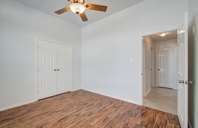12223 Ayrshire Pl, Houston, TX 77089 - unfurnished bedroom with wood finished floors, a closet, baseboards, and ceiling fan