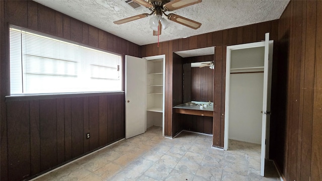 3823 Regency Dr, Houston, TX 77045 - unfurnished bedroom with wooden walls, a textured ceiling, and ceiling fan