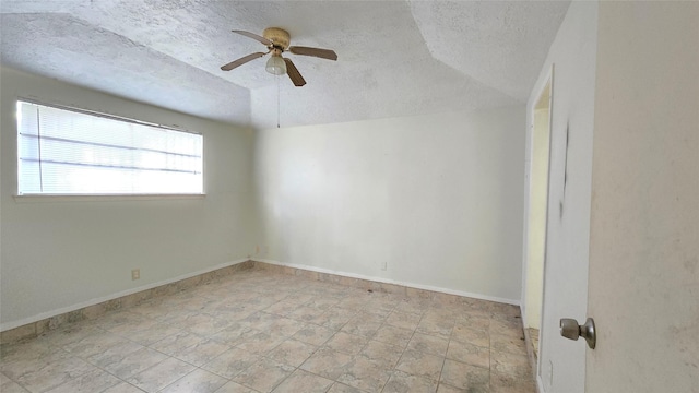 3823 Regency Dr, Houston, TX 77045 - spare room with a textured ceiling, a ceiling fan, lofted ceiling, baseboards, and stone finish floors