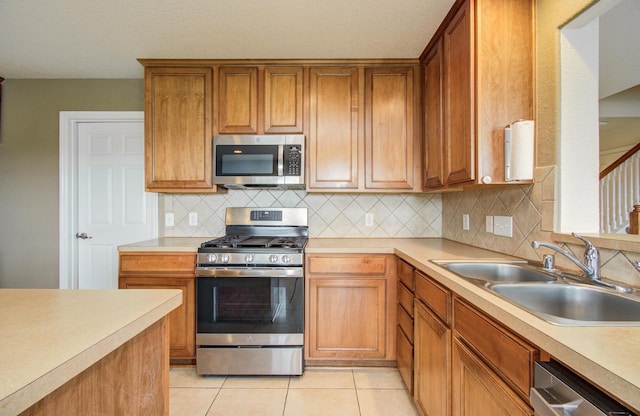 17919 Royal Gate Ln, Richmond, TX 77407 - kitchen featuring stainless steel appliances, a sink, tasteful backsplash, and light countertops